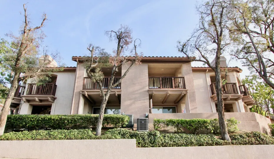 Bare trees sit in a garden patch in front of a building at the Bella Ventana community