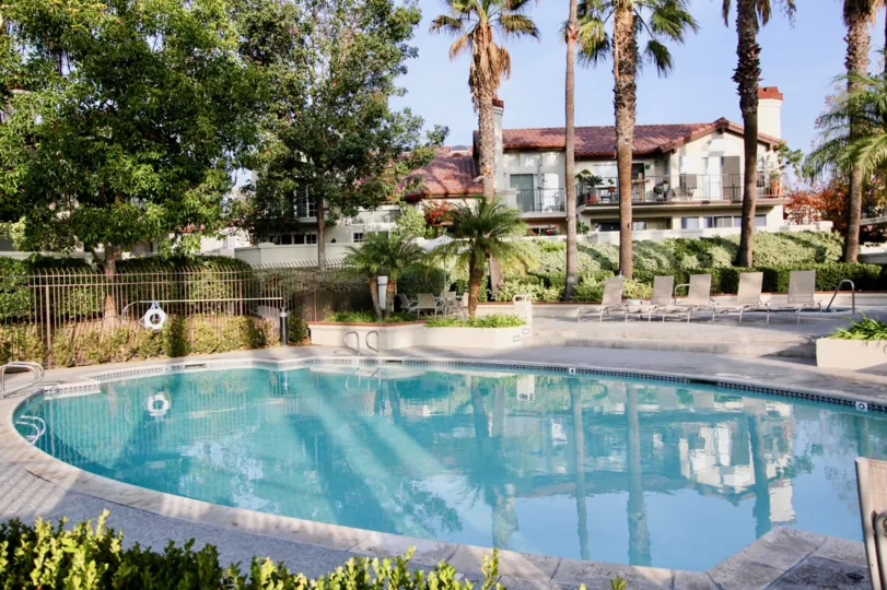 A still pool reflects a residential building in the Candelero community