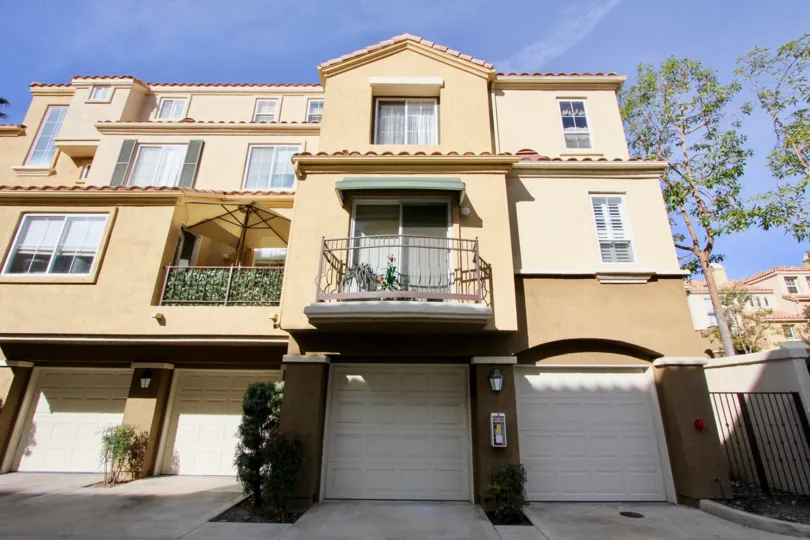 Three-storey townhouses with cream paint in the Corte Melina community.