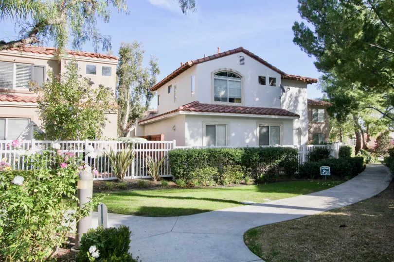 A winding foot path sits in front of townhome buildings in the Fiesta community