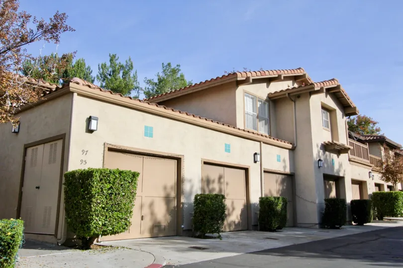 Front view of residences in Sycmore Glen in Tustin, California. Single car garages and balconies for the residents.