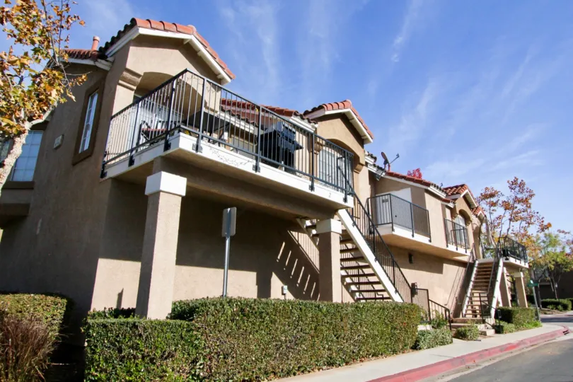 A sunny day at the Spanish style residences of Mission Courts with wrought iron railings and upstairs patios