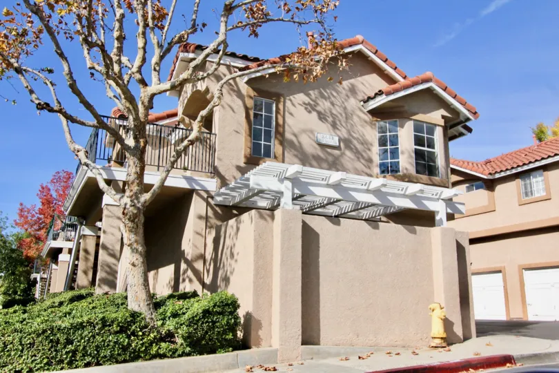 A sunny day in the area of Mission Courts, outside, trees, condo, garage, balcony, windows