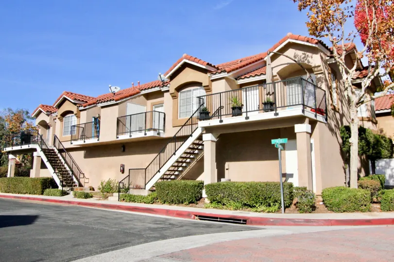 A traditional two-storey townhouse with exterior staircase in the Mission Courts community.