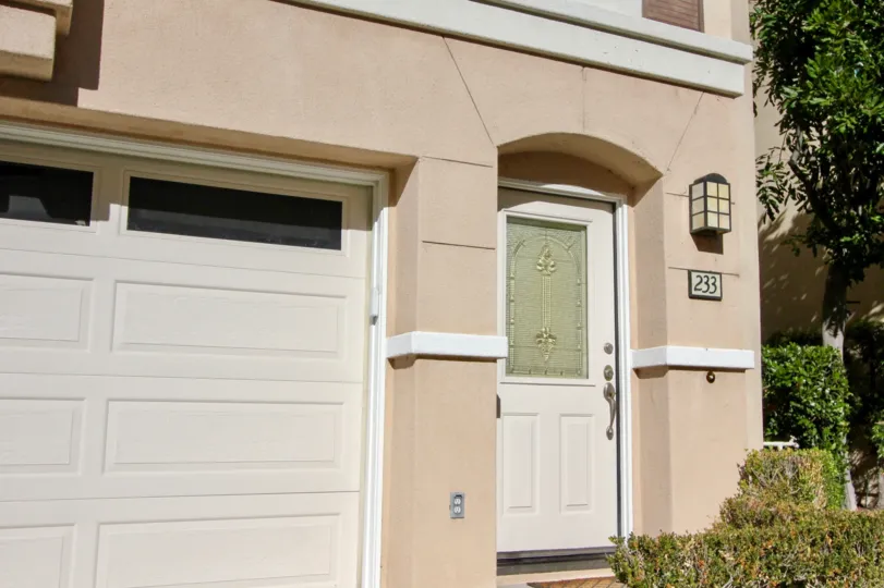 A low-rise residence painted in cream with closed carport in the Montana Del Lago community.