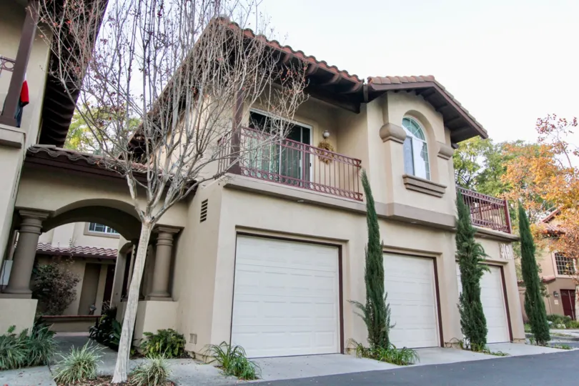 A sunny day at Serabrisa with private garage parking, upstairs patio space and evergreen landscaping