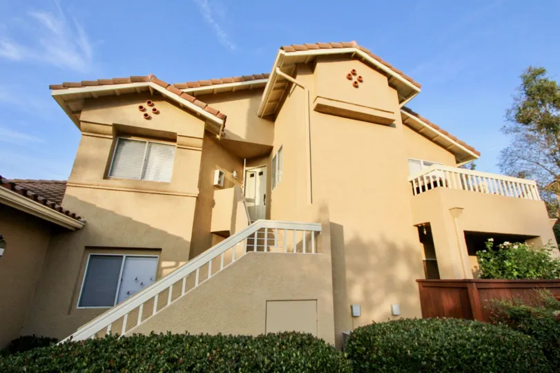 A sunny day by a Sierra Verde multiplex, painted a mostly tannish color with multiple stories and bushes in front of it