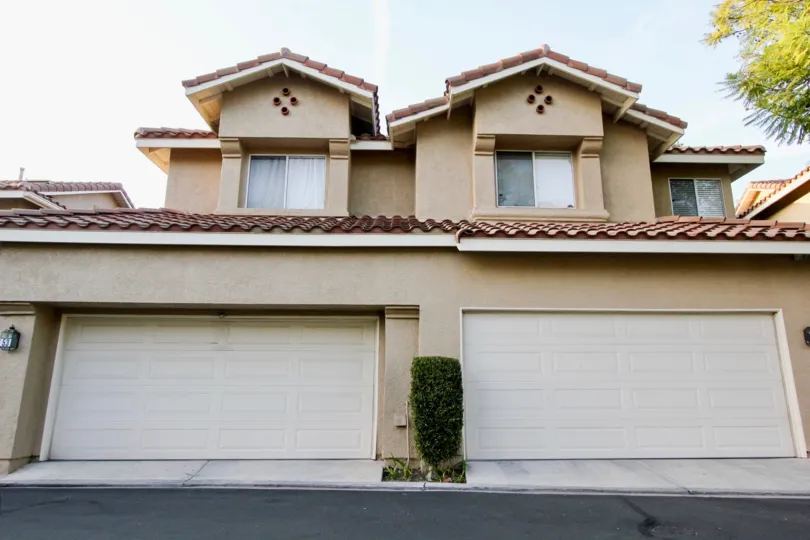 A sunny day in the area of Sierra Verde, outside, condo, garage, roof, tree, bush, garage