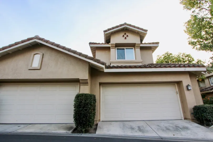 A sunny day in the area of Sierra Verde, outside, condo, garage, roof, tree, bush