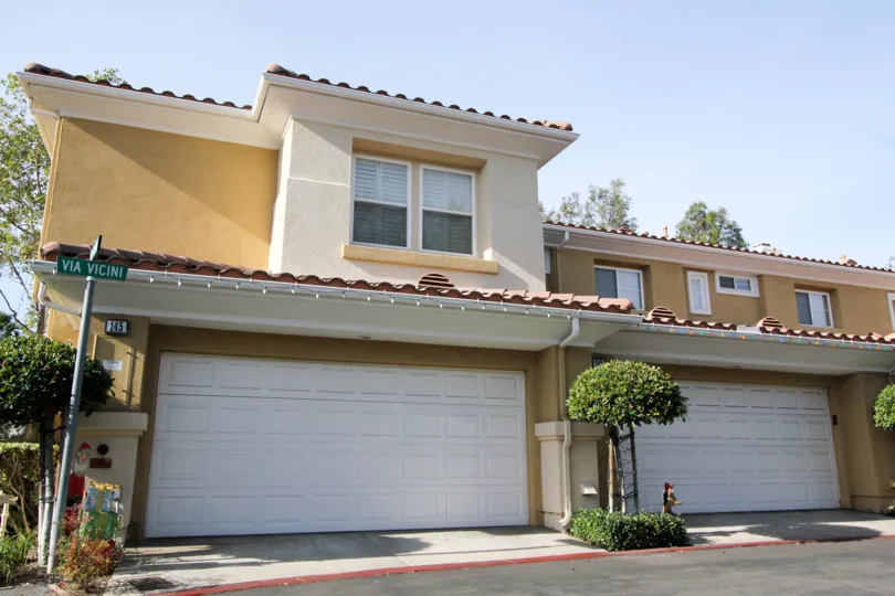 A street view of the two story, two car garage, Spanish style attached residences in the Terracina community