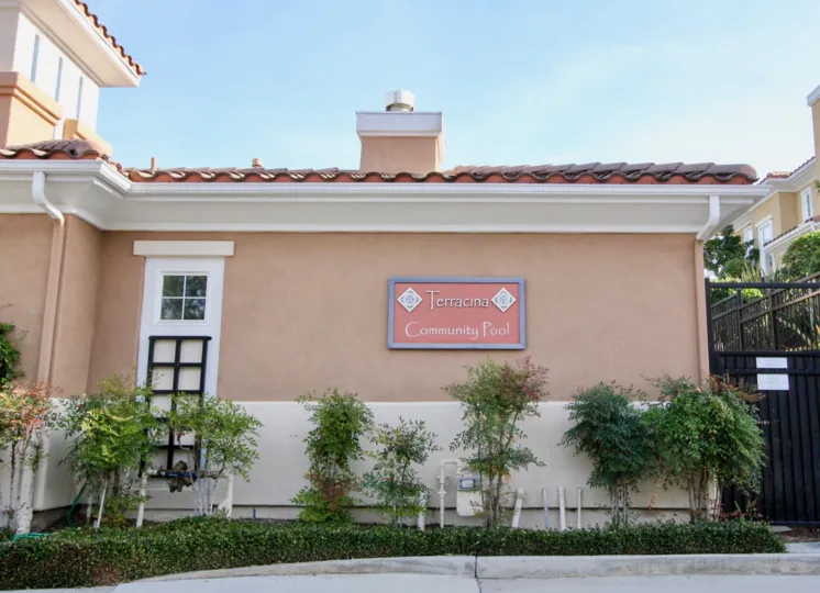 A sign sits on the wall at the Terracina condos community pool