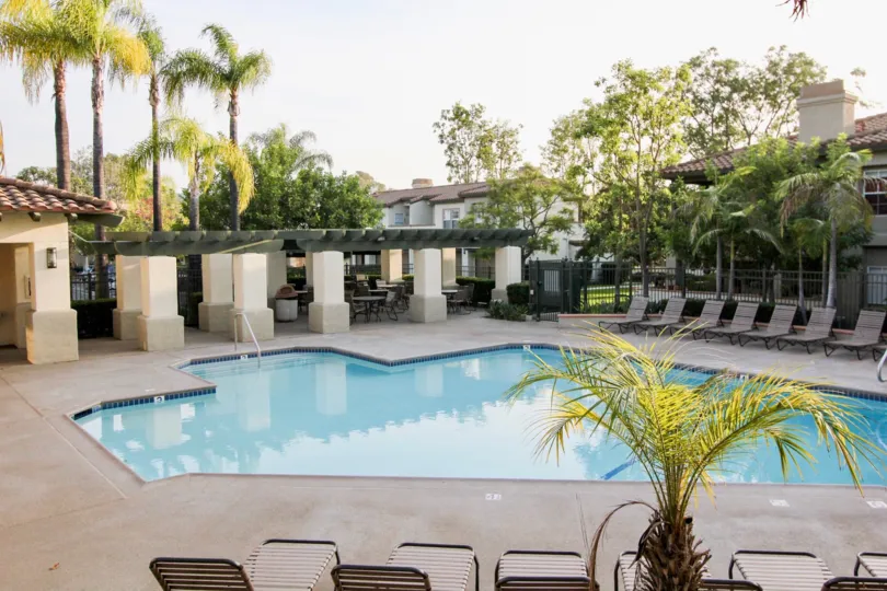 A view of the pool and lounge chairs and trees in the Tijeras Creek Villas community in Rancho Santa Margarita, CA