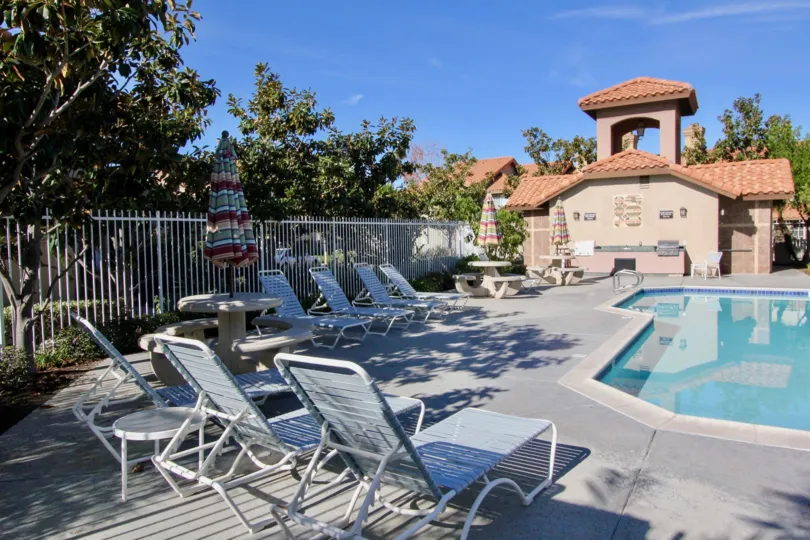 Community pool surrounded by lounge chairs in Vista La Cuesta.