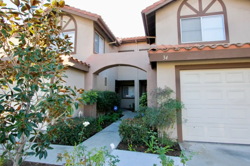 A two-storey ranch-style residence with an arched entrance in the Vista La Cuesta community.