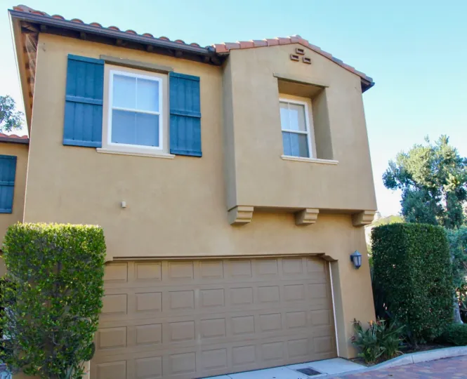 beige family home with blue window detail with garage