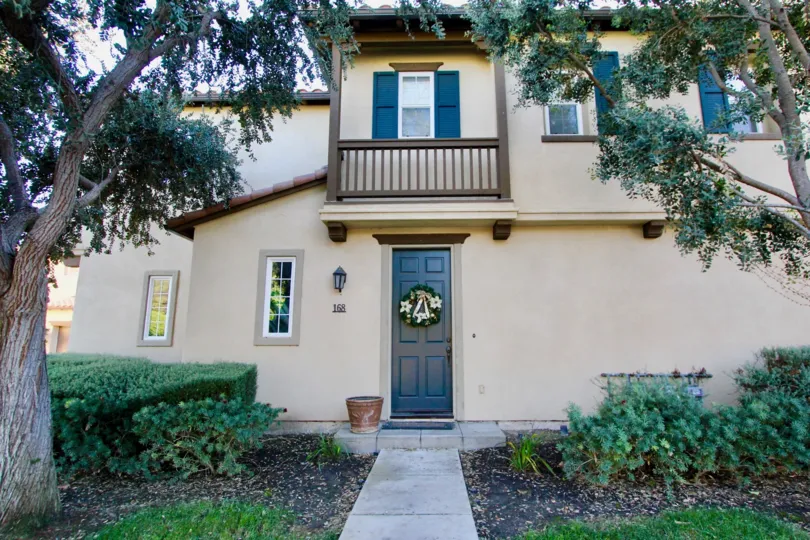 A holiday wreath sits on a blue door in the Alassio community