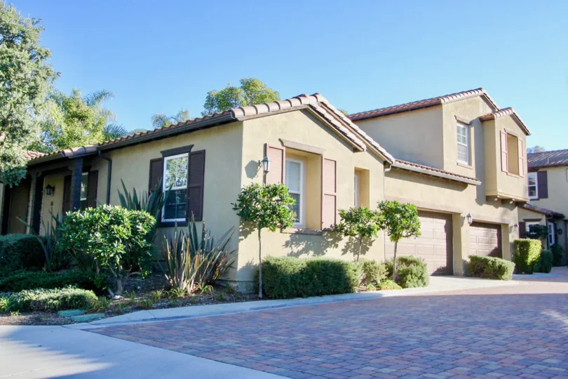 A colorful brick driveway sits in the shade at a townhome in the Alssio community