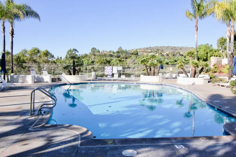 A swmming pool alone with good background nature with green fields at the morning time sunlight effect.