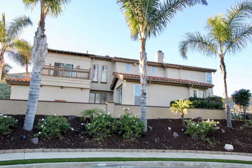 Wooden railing to the balcony and slanting roofs with brick colored in Del Cabo Estates.