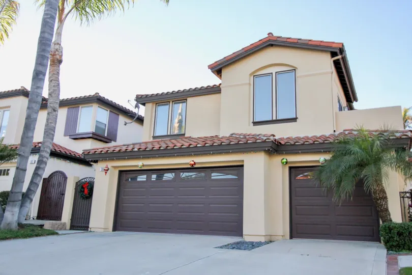 A two-storey residence with dark brown carport in the Del Cabo Estates community.