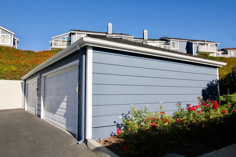 A closed two-car carport in the Faire Harbour community painted in blue.