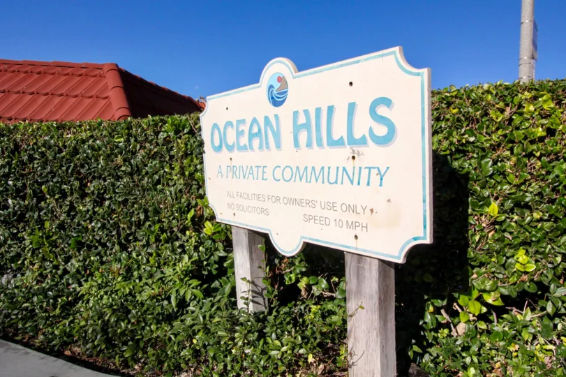 The sign of a private community called Ocean Hills surrounded by trimmed shrubbery in San Clemente, California