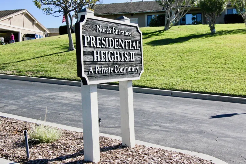 A sign board is placed in the President Heights II nearby the road.
