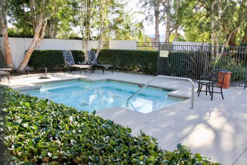 THE SWIMMING POOL IN THE SEAGARDEN WITH THE CHAIRS, TREES, PLANTS