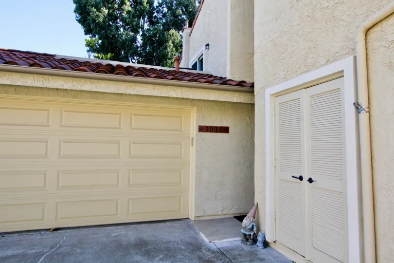 A closed carport with louvered back door access in the Sunset Village community.