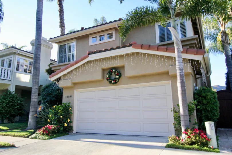 A wreath with gold and red balls decorate the front of a garage in Villamar