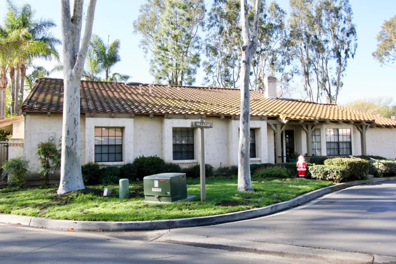 A single storied home with a garden space and a santa like figurine in the garden