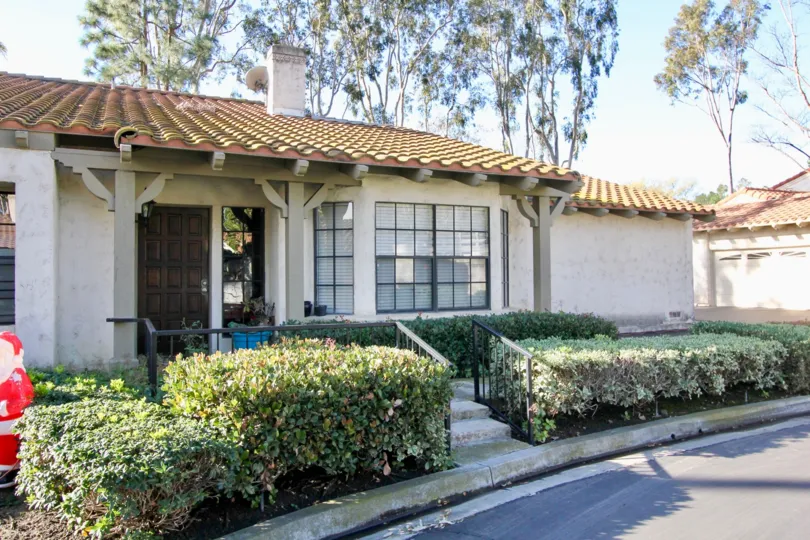 A sunny day in the area of Capistrano D'Oro, outside, door, stairs, railing, bushes, roof, garage