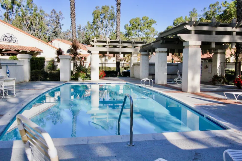 A pool with chairs and tables around it in Capistrano D'Oro community in San Juan Capistrano, California.