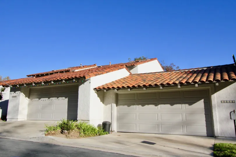 A sunny day with blue skies by a couple of garages in the Captains Hill area