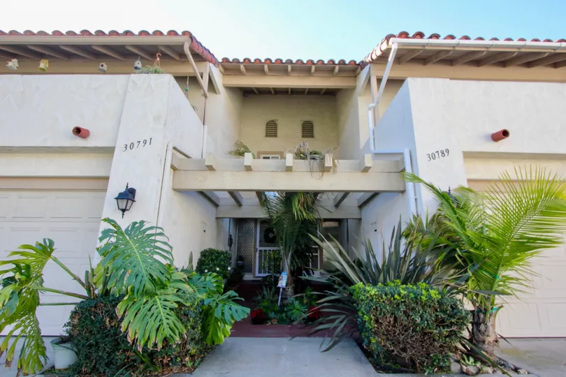 Palm trees and buses surround the front door of a townhome in Casitas Capistrano