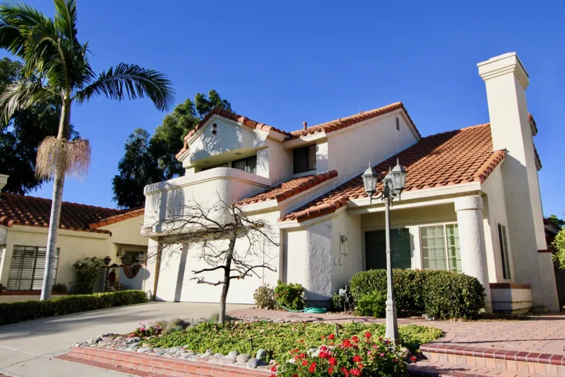 A two story white residential home with a tile roof in Casitas Del Rio in San Juan Capistrano in the state of California.