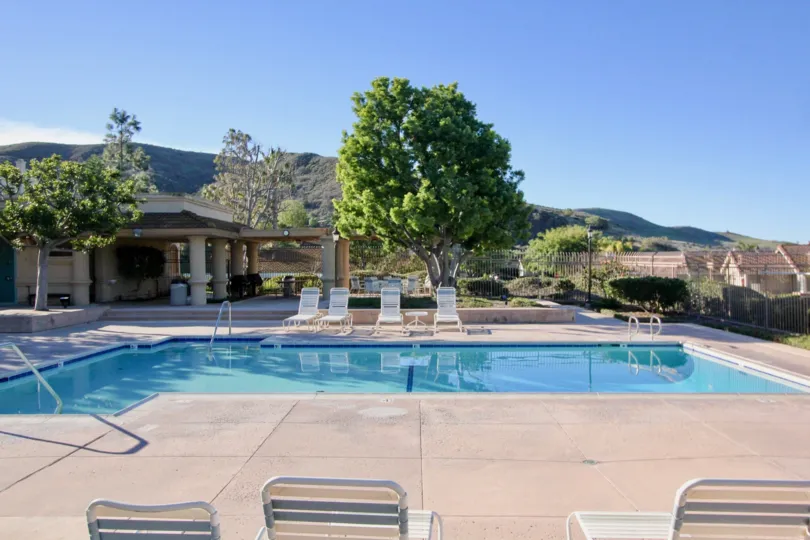 A medium pool with chairs and mountains in Loma Vista community in San Juan Capistrano, california.