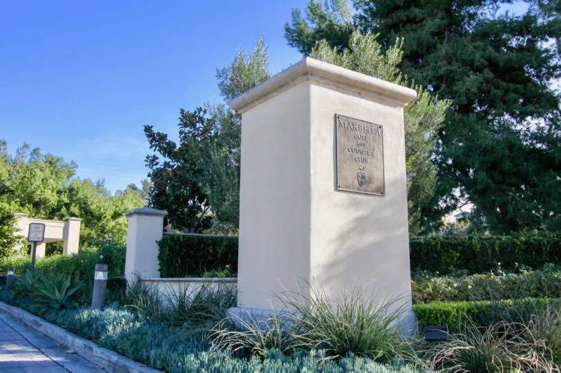 Trees and a welcome sign to Marbella Golf Villas in San Juan Capistrano, CA