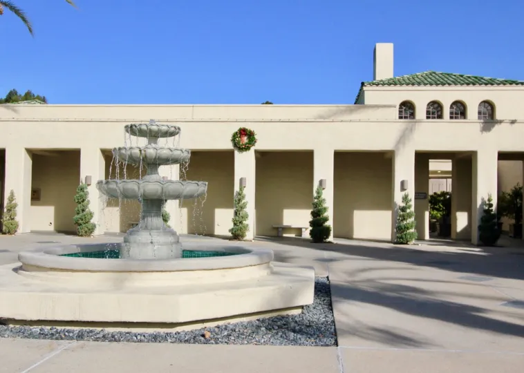 Flowing fountain in a courtyard of large building on a clear day