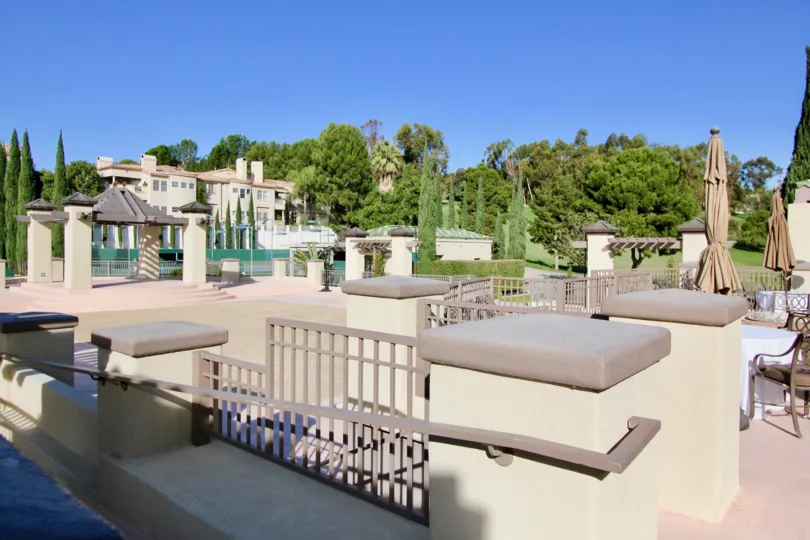 A tiled courtyard with decorative fences and closed umbrellas in the Marbella Golf Villas community.