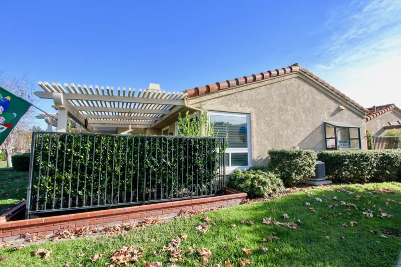 A sunny day in the area of Mesa Verde, condo, fence, bushes, grass, windows