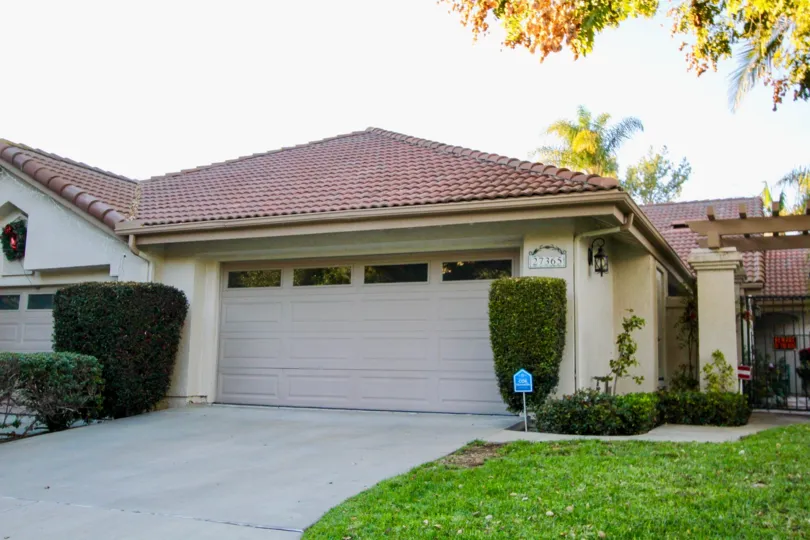 A white home with red roof and garages at Mesa Vista North community in San Juan Capistrano, California.