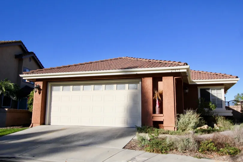 A potted palm tree sits in a nook on a garage of a homes at Mesa Vista South