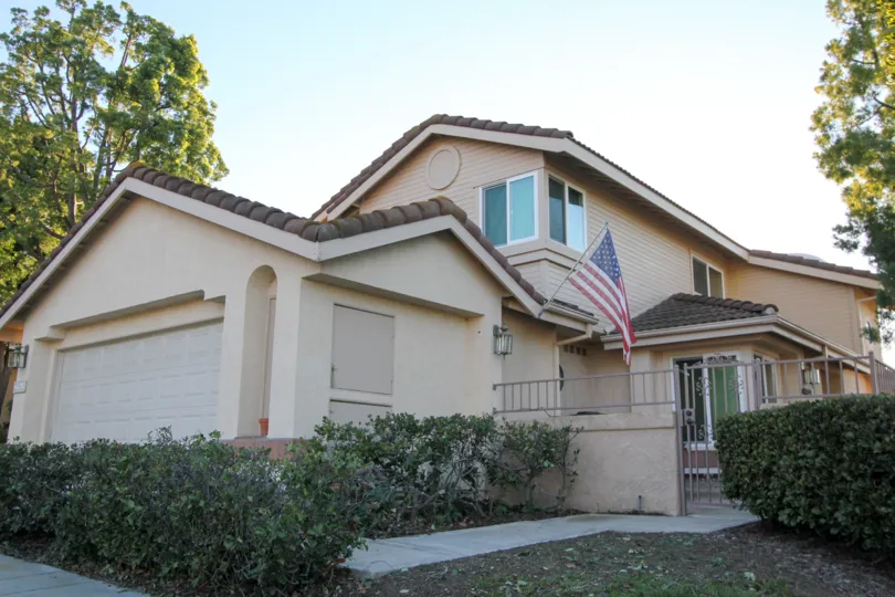 A tan home with a flag outside in San Juan Hills community in San Juan Capistrano, California.