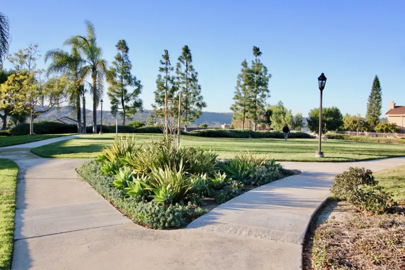 a sunny day in the san juan hills with park that has garden in the front of tall tree in the front of top out post