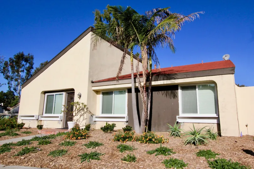 Dry tan mulch covers the yard in front of a house in Sun Hollow