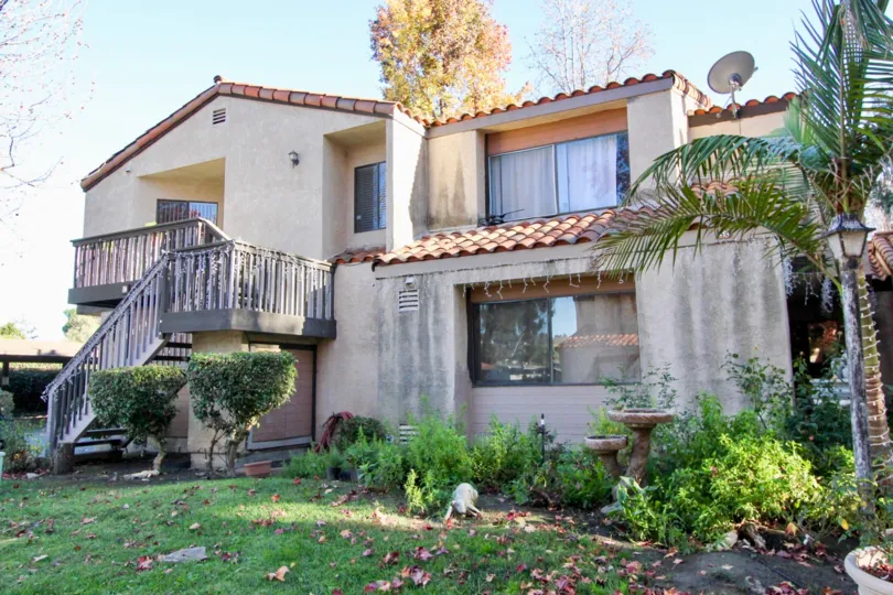 A yellow tree with few leafs left sits behind a townhome in the Valle Pacifica community