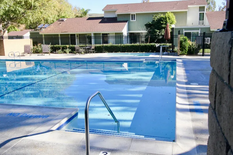 No diving sign painted next to a large clear pool at the Village San Juan Townhomes community in San Juan Capistrano, California.