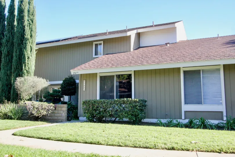 A beautiful manicured lawn sits in front of a townhome in Village San Juan Townhomes