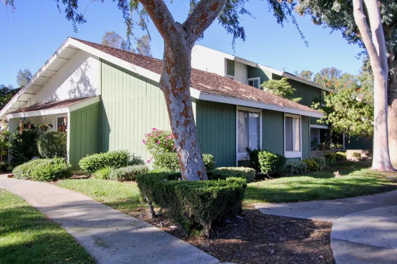 Shaded, green panelled townhome in the Village of Saun Juan, located in San Juan Capistrano.
